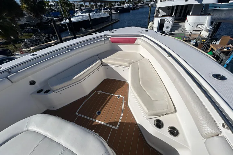 Slide: The Image of 2012 Boston Whaler 370 Outrage boat interior with cushioned seating and wood-style flooring. - 11