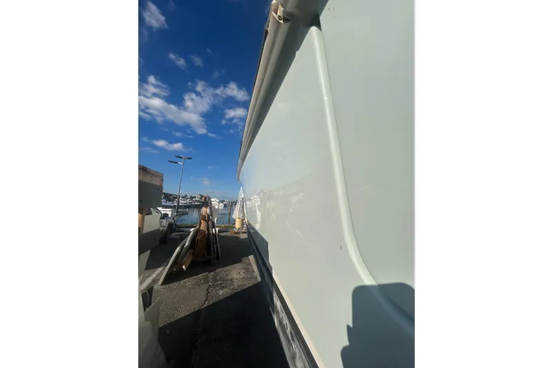 Slide: The Image of Side view of a 2012 Boston Whaler 370 Outrage boat under a clear blue sky. - 12