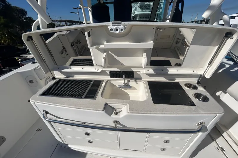 Slide: The Image of 2012 Boston Whaler 370 Outrage boat kitchen with sink, grill, and storage compartments. - 5