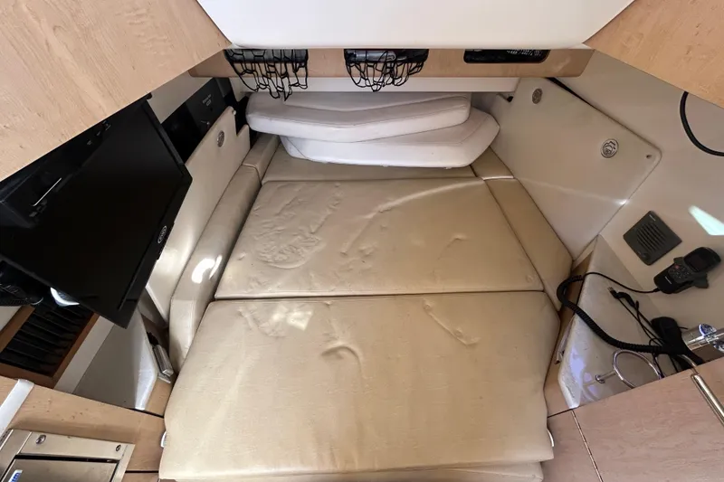 Slide: The Image of 2012 Boston Whaler 370 Outrage cabin interior with beige cushions and modern amenities. - 8