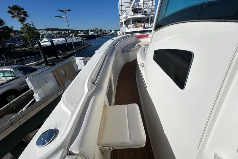 Slide: The Image of 2012 Boston Whaler 370 Outrage boat docked, showcasing sleek design and spacious deck. - 9