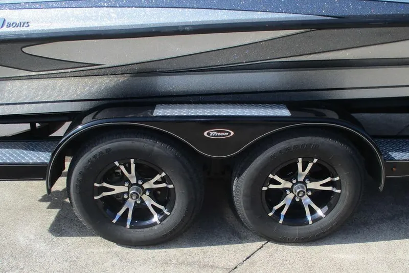 Slide: The Image of 2011 Triton 21XS Elite boat trailer with dual black wheels and sleek design. - 10