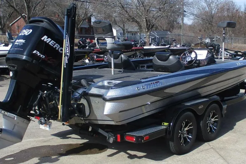 Slide: The Image of 2011 Triton 21XS Elite boat with Mercury engine on trailer, parked outdoors. - 4