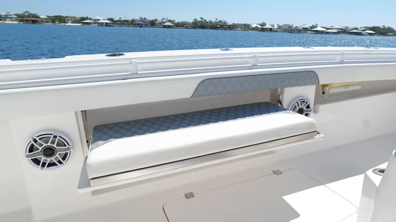 Slide: The Image of Invincible 37 Catamaran 2020, featuring a cushioned seating area and speakers, on a sunny day. - 42
