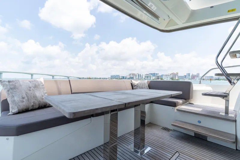 Slide: The Image of 2019 Prestige 520 Flybridge yacht with outdoor seating and dining area. - 28