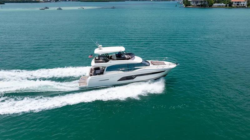Slide: The Image of 2019 Prestige 520 Flybridge yacht cruising on open water. - 42