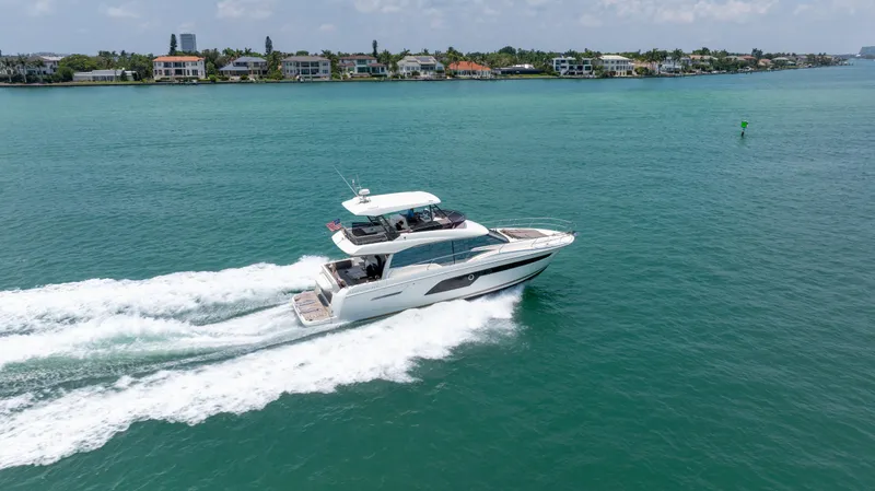 Slide: The Image of 2019 Prestige 520 Flybridge yacht cruising on a scenic waterway. - 5