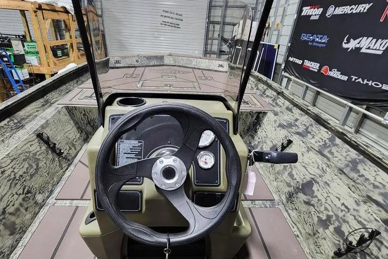 Slide: The Image of 2026 Tracker Grizzly 2072 CC boat interior with steering wheel and control panel. - 2