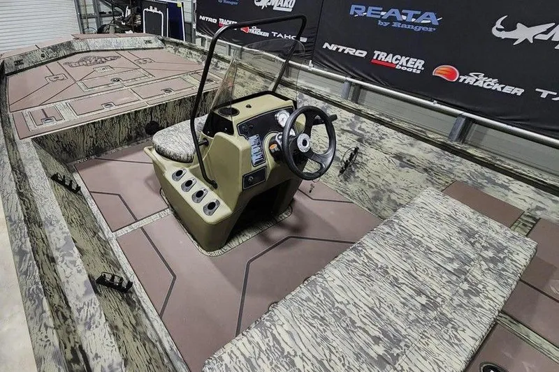 Slide: The Image of 2026 Tracker Grizzly 2072 CC boat interior with camouflage design and central console. - 5