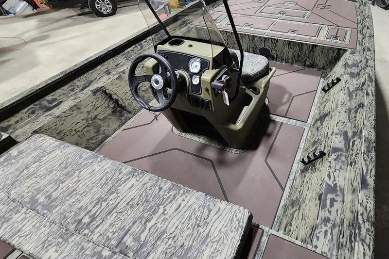 Slide: The Image of 2026 Tracker Grizzly 2072 CC boat interior with camouflage design and steering console. - 8