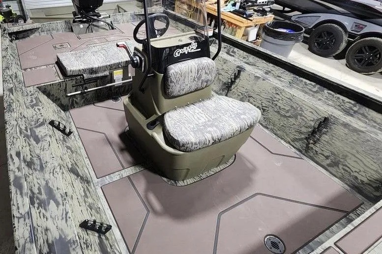 Slide: The Image of 2026 Tracker Grizzly 2072 CC boat interior with camouflage seating and steering console. - 9