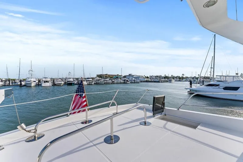Slide: The Image of Deck view from 2000 West Bay 58 Sonship yacht in marina with American flag. - 38
