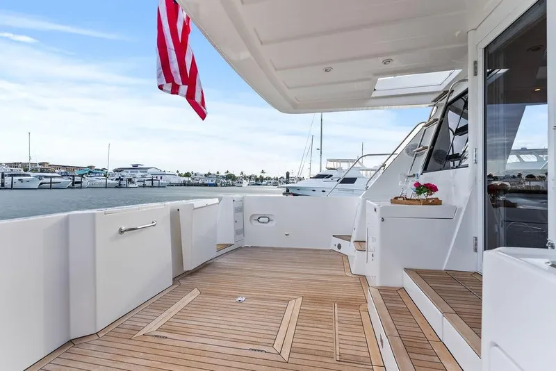 Slide: The Image of Luxurious 2000 West Bay 58 Sonship yacht deck with elegant wood flooring and marina view. - 4