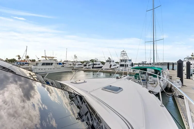 Slide: The Image of Marina with West Bay 58 Sonship yacht, 2000 model, docked under clear blue sky. - 43