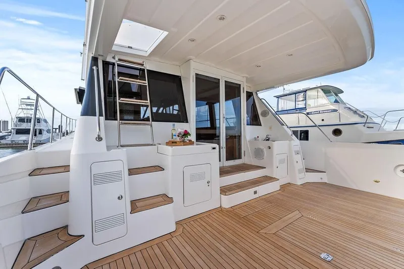 Slide: The Image of Luxurious 2000 West Bay 58 Sonship yacht deck with elegant wood finish and modern amenities. - 46