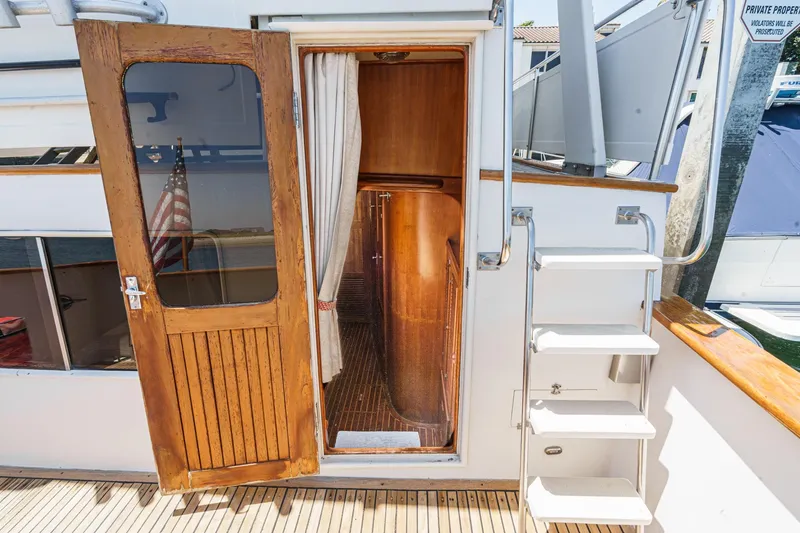 Slide: The Image of Entrance of 1986 Offshore Yachts Cockpit Motoryacht with wooden door and stairs. - 21