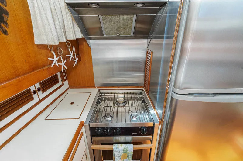 Slide: The Image of 1986 Offshore Yachts Cockpit Motoryacht kitchen with stove and refrigerator. - 20