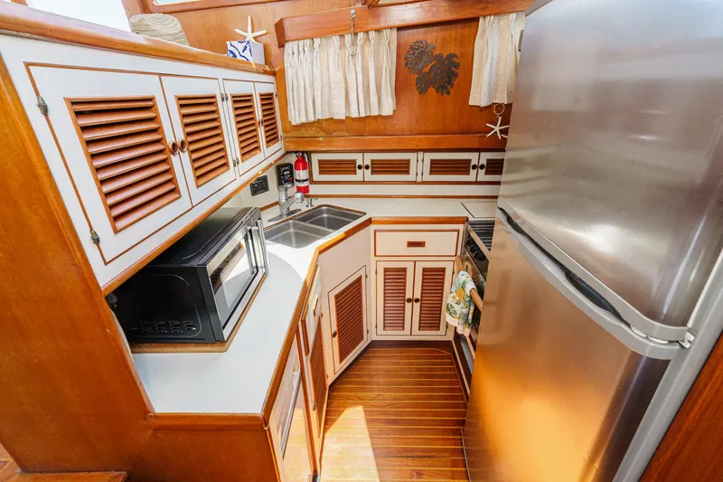 Slide: The Image of 1986 Offshore Yachts Cockpit Motoryacht kitchen with wood paneling. - 19