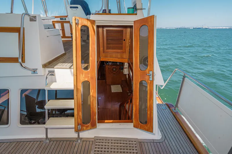 Slide: The Image of 1986 Offshore Yachts Cockpit Motoryacht with open wooden door and sea view. - 8