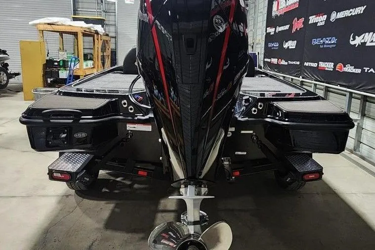 Slide: The Image of 2026 Triton 20XP Patriot boat in showroom, rear view with powerful engine. - 2