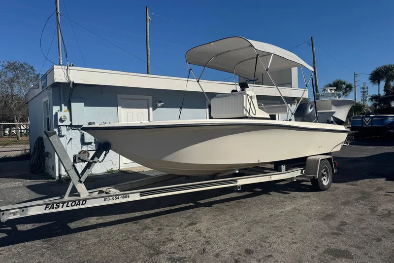 Slide: The Image of 2001 Sea Fox 195 Bay Fisher boat on trailer, parked outdoors under clear blue sky. - 0