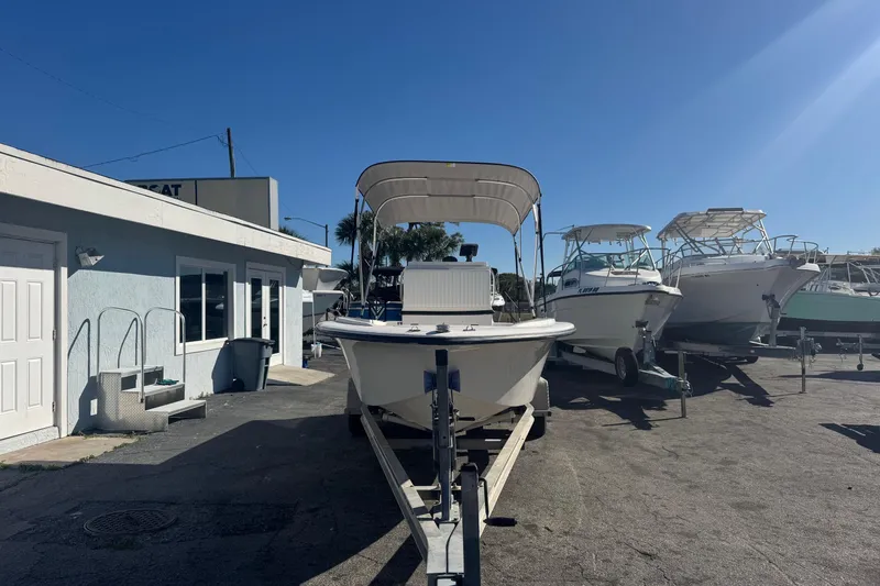 Slide: The Image of 2001 Sea Fox 195 Bay Fisher boat on trailer, parked outside a building under clear blue sky. - 1