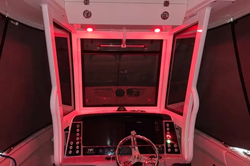 Slide: The Image of 2022 Robalo R272 Center Console boat helm with red lighting and modern controls. - 10
