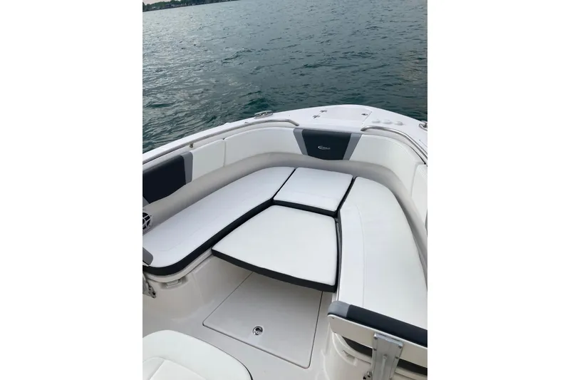 Slide: The Image of 2022 Robalo R272 Center Console boat anchor compartment with open hatch, near water. - 15