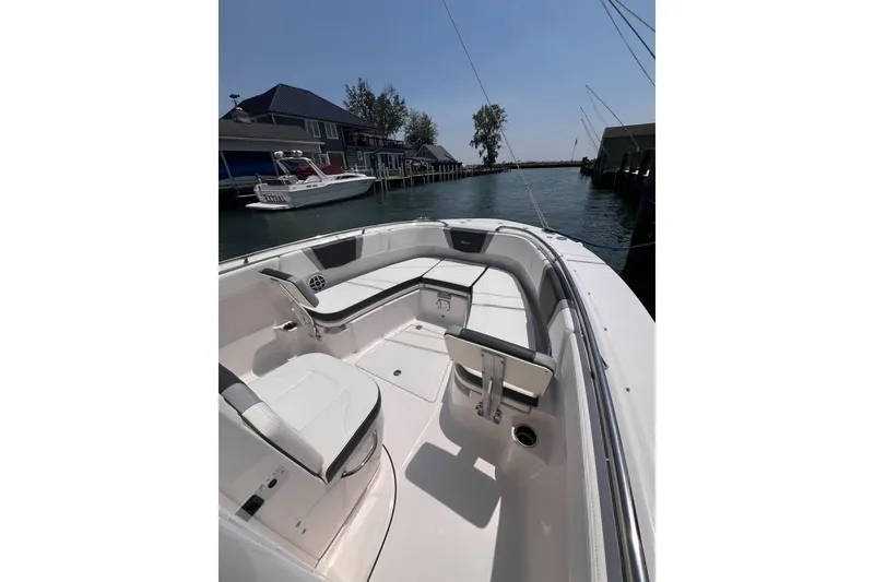 Slide: The Image of 2022 Robalo R272 Center Console boat interior with open storage compartments on a lake. - 16