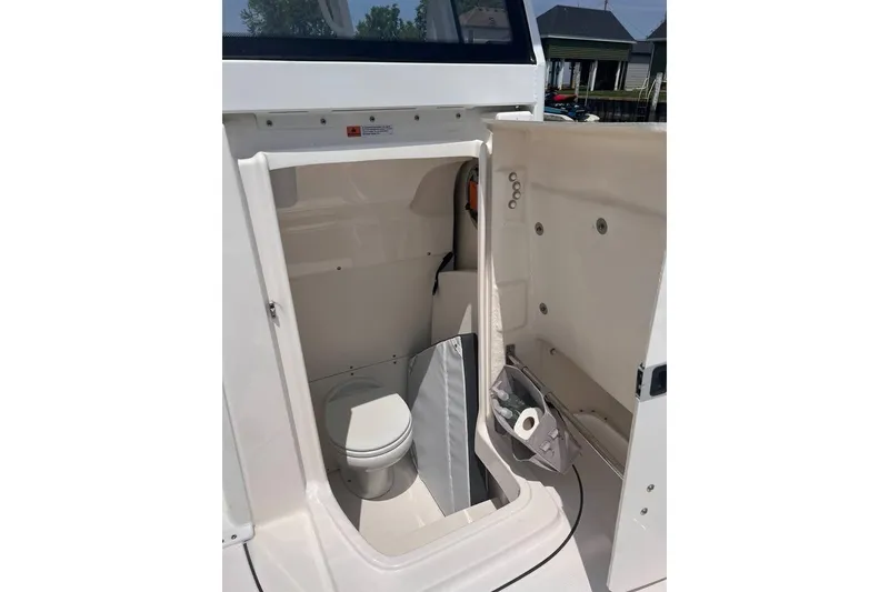 Slide: The Image of 2022 Robalo R272 Center Console boat interior with compact marine toilet. - 17