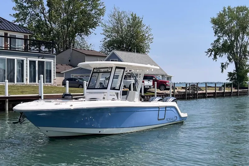 Slide: The Image of 2022 Robalo R272 Center Console boat docked near waterfront homes. - 2