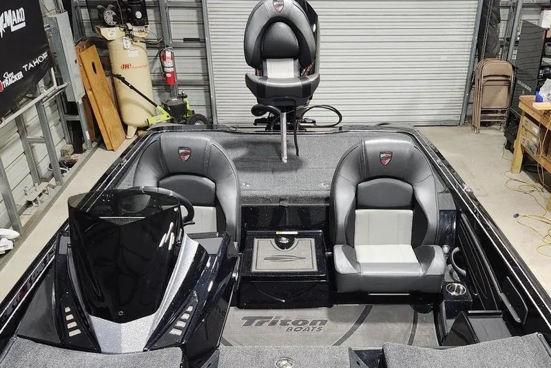 Slide: The Image of 2026 Tracker Grizzly 12 Jon boat interior with seating and control panel in a garage. - 13