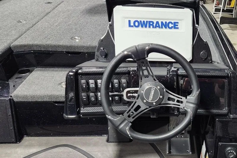 Slide: The Image of 2026 Tracker Grizzly 12 Jon boat dashboard with Lowrance display and steering wheel. - 6