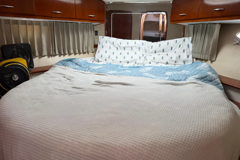 Slide: The Image of Interior of 2003 Carver 360 Sport Sedan with bed, fan, and wooden cabinets. - 25