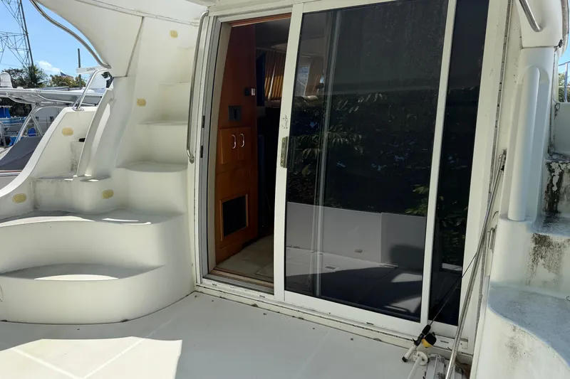 Slide: The Image of 2003 Carver 360 Sport Sedan deck with lush greenery and red flowers. - 5