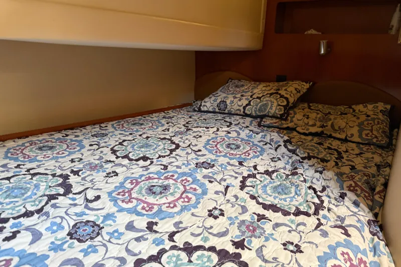 Slide: The Image of Cozy bedroom in 2003 Carver 360 Sport Sedan with blue bedding and wooden cabinets. - 24