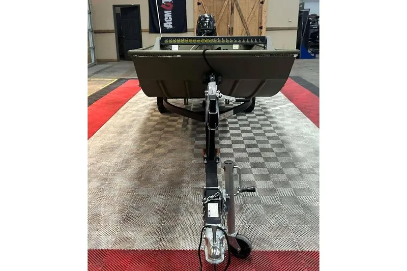 Slide: The Image of 2024 Lowe L1448 Jon boat on trailer, displayed indoors on checkered flooring. - 13