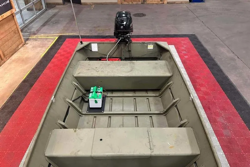 Slide: The Image of 2024 Lowe L1448 Jon boat interior with motor and battery on display. - 8