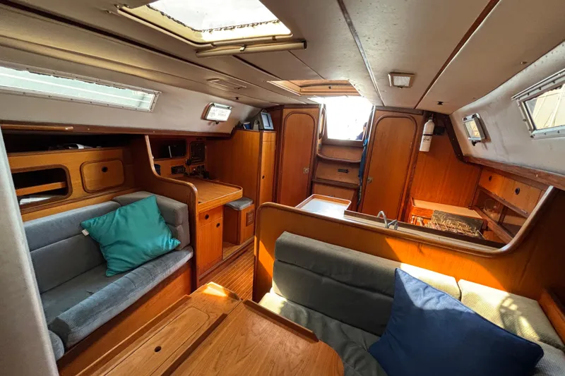 Slide: The Image of Interior of 1986 Beneteau First 375 sailboat, featuring cozy seating and wooden cabinetry. - 6