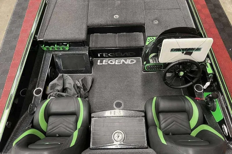 Slide: The Image of 2018 Legend Boats V20 interior with black and green seats, steering wheel, and dashboard. - 6