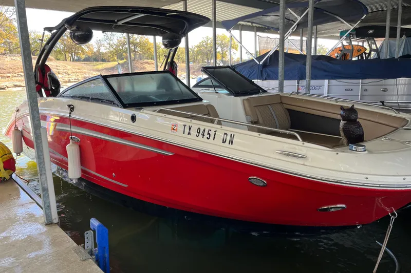 Slide: The Image of 2016 Sea Ray 270 Sundeck boat with red hull docked in marina. - 12