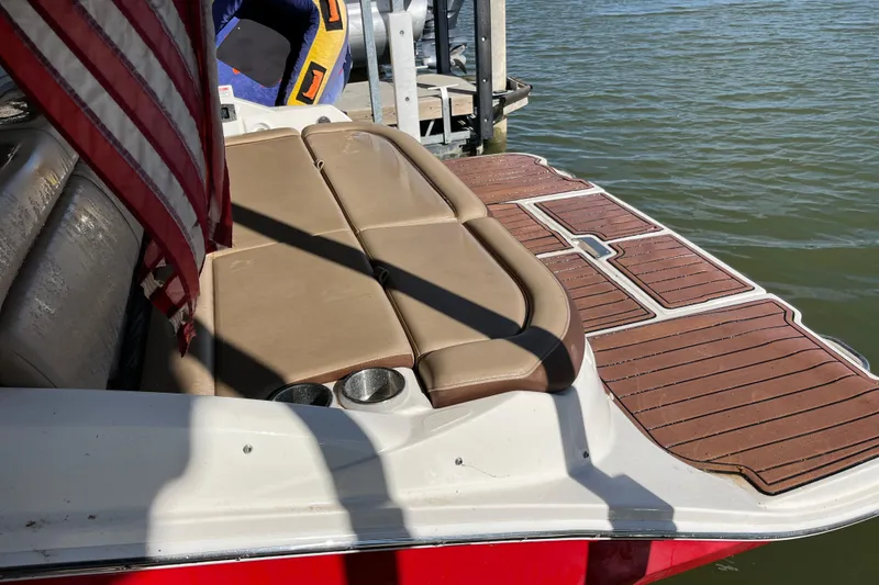 Slide: The Image of 2016 Sea Ray 270 Sundeck boat with tan seating and wooden deck by the water. - 15