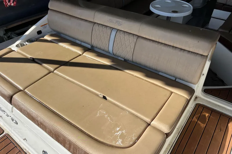 Slide: The Image of 2016 Sea Ray 270 Sundeck boat seating with tan upholstery and wooden deck. - 16