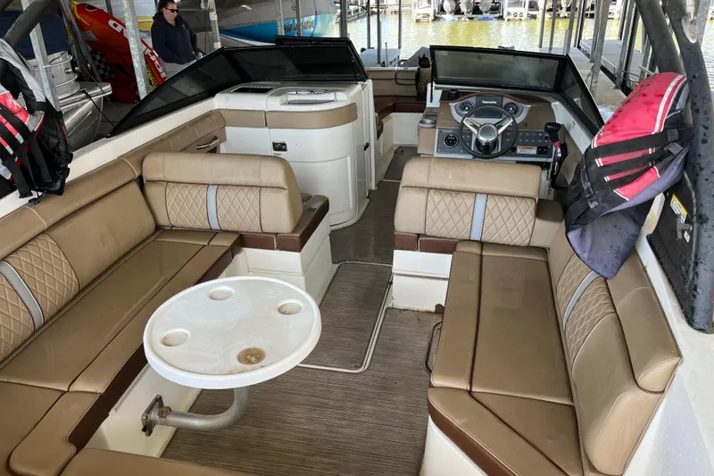 Slide: The Image of 2016 Sea Ray 270 Sundeck interior with beige seating and steering console. - 17