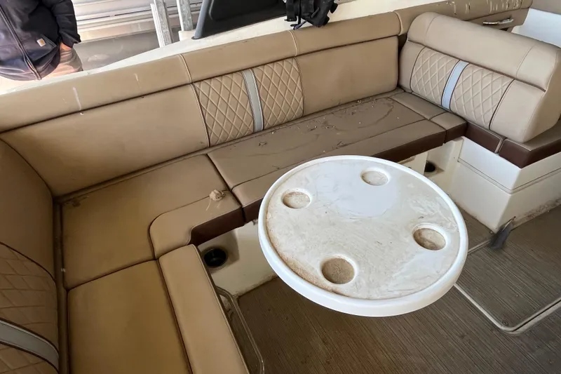 Slide: The Image of 2016 Sea Ray 270 Sundeck interior with beige seating and round table. - 5