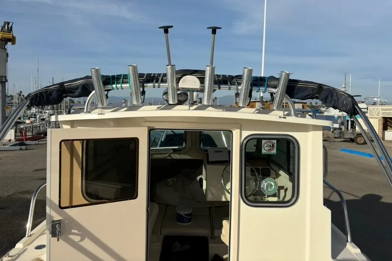 Slide: The Image of 2008 Parker 2320 SL Sport Cabin boat at marina, rear view with fishing rod holders. - 10