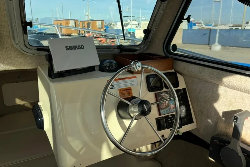 Slide: The Image of 2008 Parker 2320 SL Sport Cabin boat interior with steering wheel and Simrad navigation system. - 12