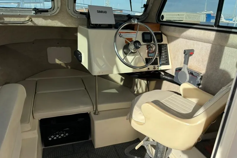 Slide: The Image of Interior of a 2008 Parker 2320 SL Sport Cabin boat with steering wheel and seating. - 15