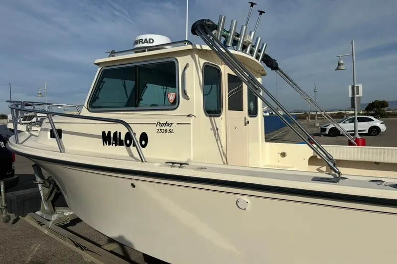 Slide: The Image of 2008 Parker 2320 SL Sport Cabin boat on trailer, parked in a marina. - 6