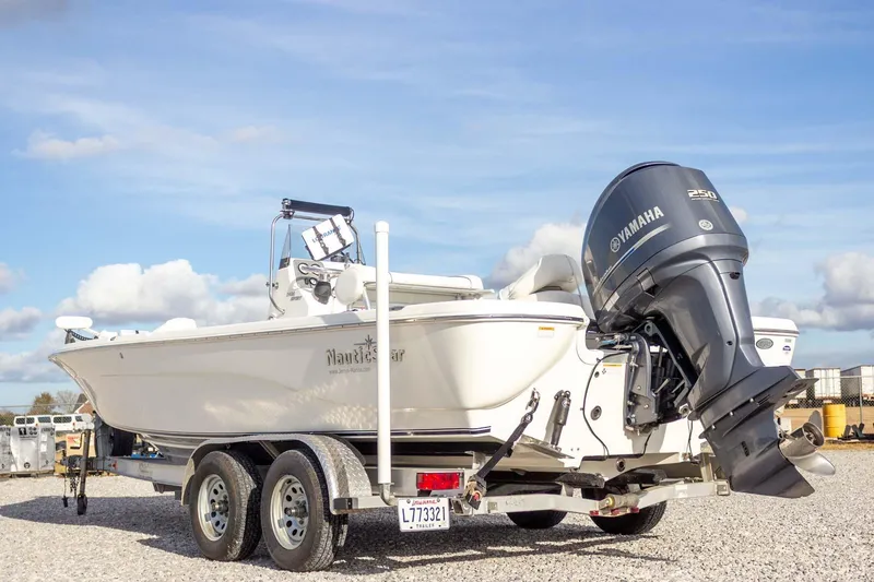Slide: The Image of 2014 NauticStar 2400 Sport boat with Yamaha engine on trailer, under blue sky. - 10